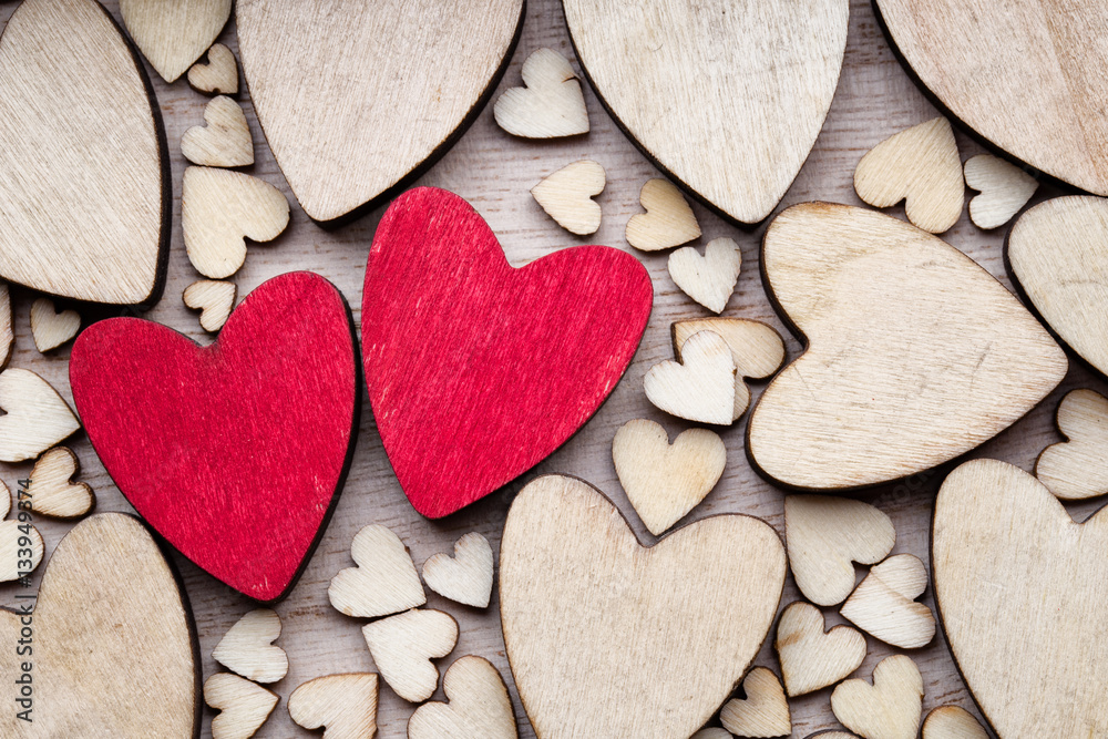 Wooden hearts, one red heart on the heart background. Wooden hearts, one red heart on the heart background.