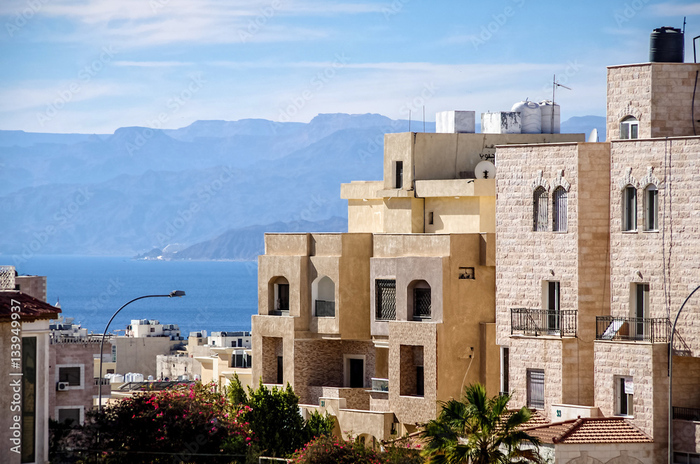 Aqaba city. Typical Aqaba buildings on the foreground. the Gulf of Aqaba and mountains on the background.