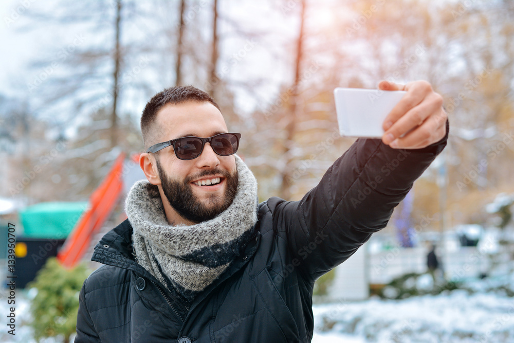 Fototapeta premium Young Man Smile Camera Taking Selfie Photo In Winter Snow Forest Guy Outdoors Walking White Park