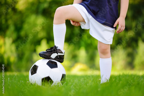 Close-up of a child having fun playing a soccer game on sunny summer day