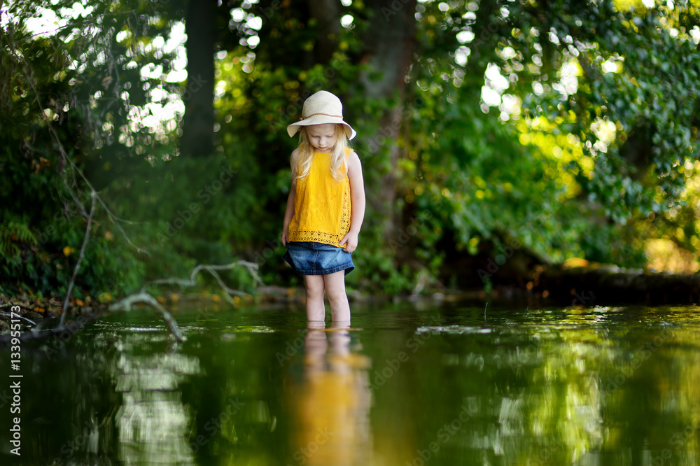 Cute little girl having fun by a river on sunny summer day Cute little girl having fun by a river on sunny summer day