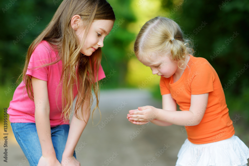 Two adorable little girl catching babyfrogs