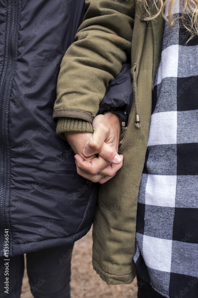 Midsection of couple holding hands