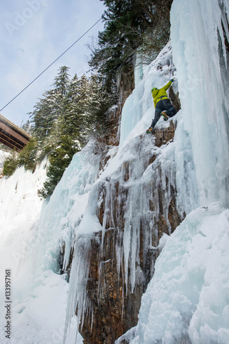 Ice Climber in green jacket with ice axe