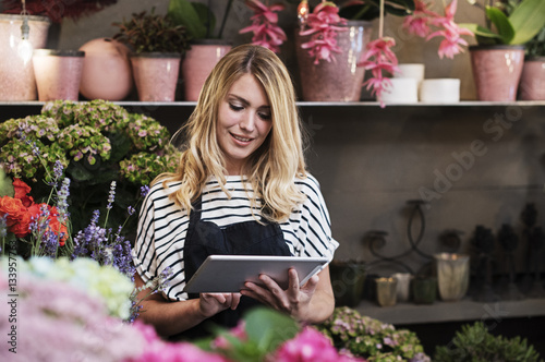 Florist using tablet computer in flower shop photo