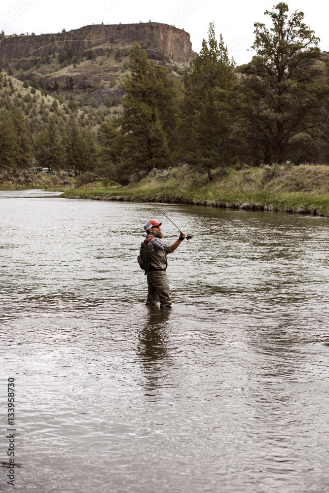 Side view of mature man fishing in river Side view of mature man fishing in river