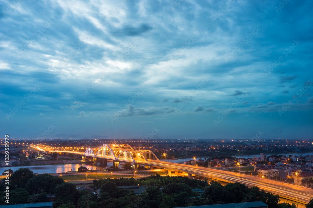 Obraz premium Aerial view of Dong Tru bridge crossing Red River at twilight in Hanoi, Vietnam