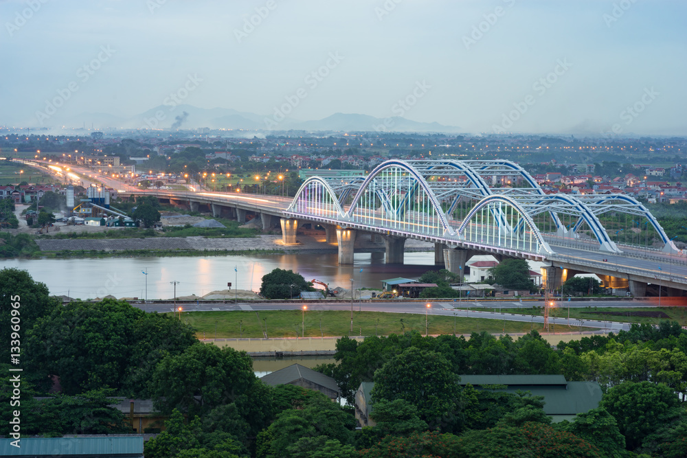 Fototapeta premium Aerial view of Dong Tru bridge crossing Red River at twilight in Hanoi, Vietnam