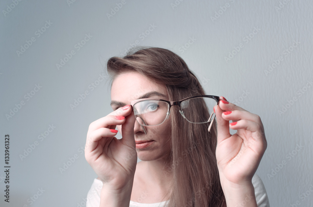 Young woman is watching through glasses