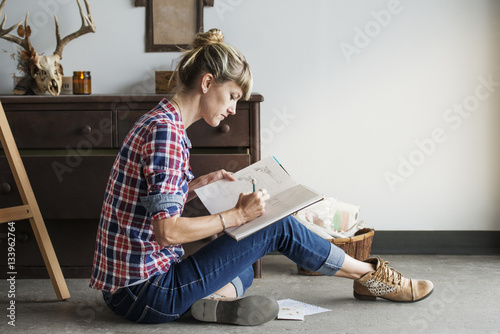 Female artist drawing in book while sitting at home photo