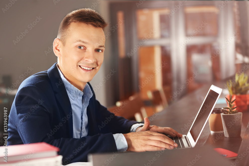 Handsome man with laptop studying in library Handsome man with laptop studying in library