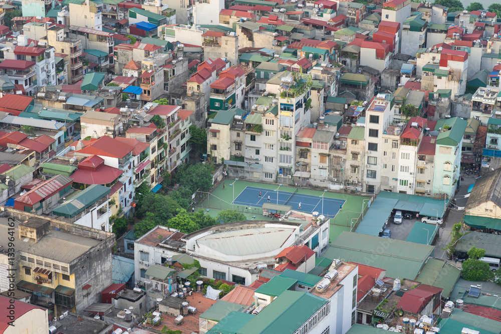 Aerial view of crowded resident houses in Chuong Duong Do, Hoan Kiem district, Hanoi, Vietnam. A tennis court staying among the houses