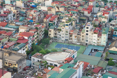 Aerial view of crowded resident houses in Chuong Duong Do, Hoan Kiem district, Hanoi, Vietnam. A tennis court staying among the houses © Hanoi Photography