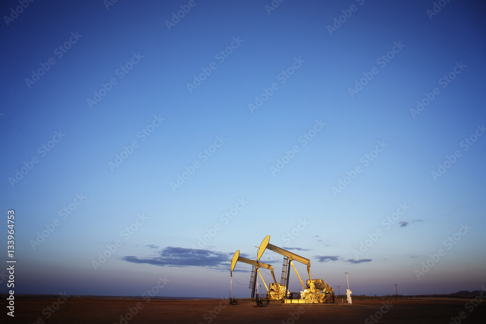 Oil pumps on field against blue sky Oil pumps on field against blue sky