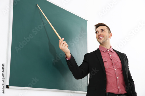 Young male teacher beside b...