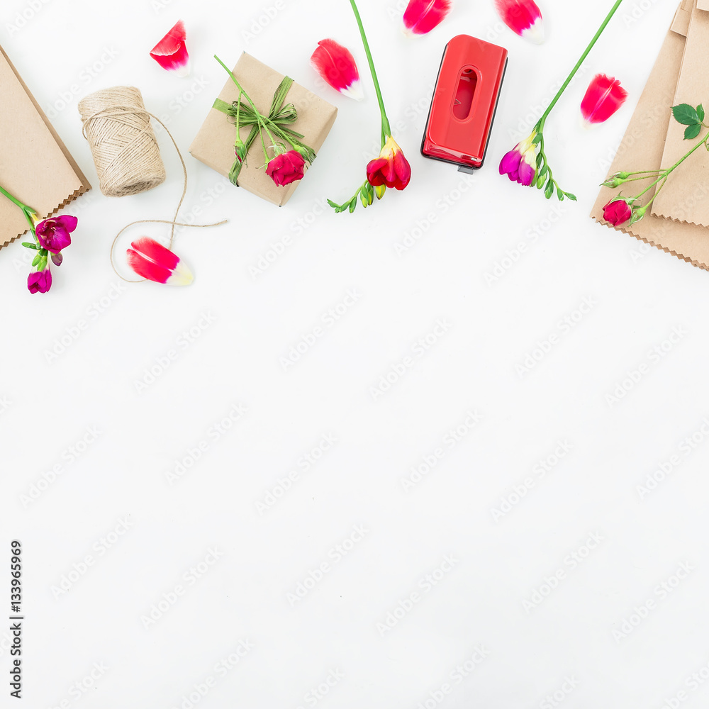 Frame with red flowers, gift box and details isolated on white background. Flat lay, Top view.