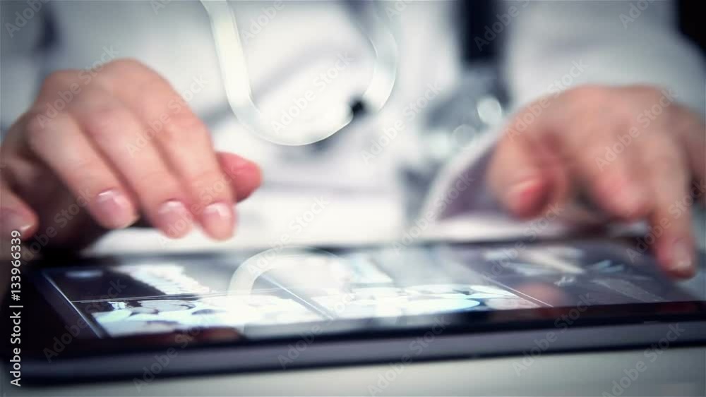 Doctor Examines An X-ray Of Patient On Digital Tablet Doctor Examines An X-ray Of Patient On Digital Tablet