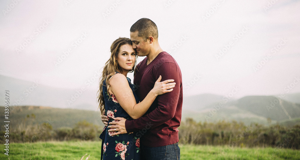 Portrait of woman embracing husband while standing on field during foggy weather Portrait of woman embracing husband while standing on field during foggy weather