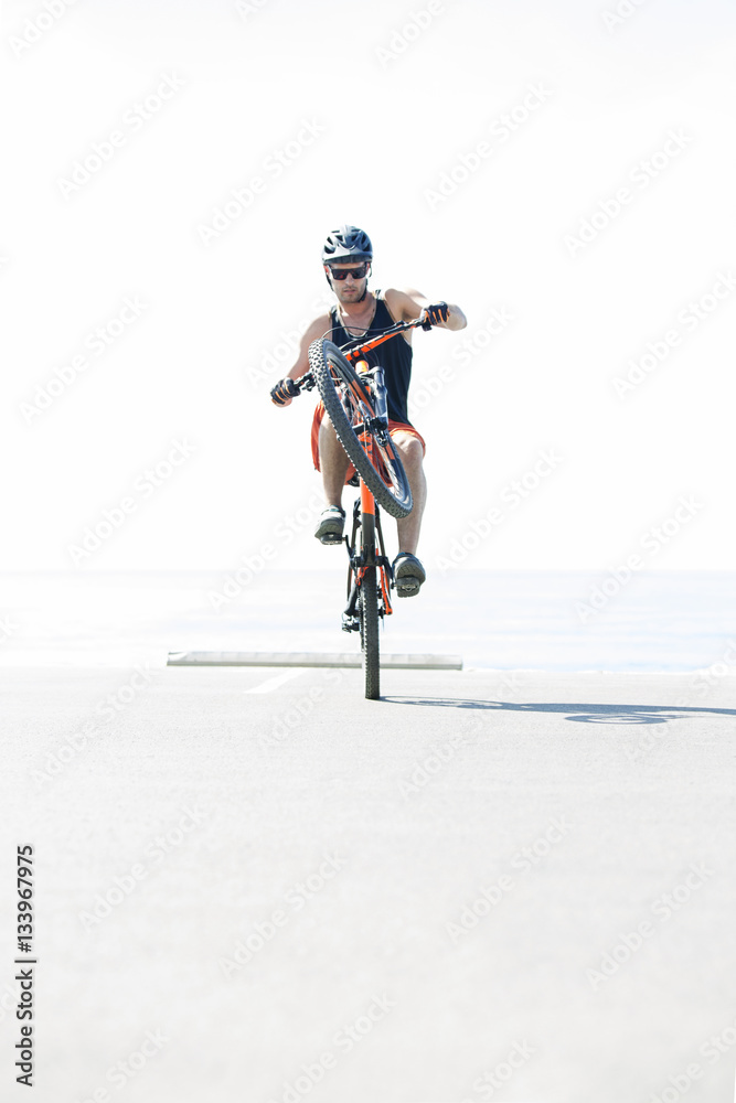 Man performing stunt with bicycle sunny day Man performing stunt with bicycle sunny day