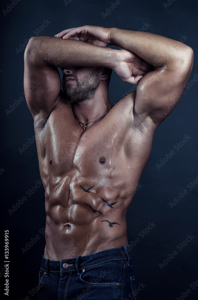 Handsome bodybuilder poses on dark background Handsome bodybuilder poses on dark background