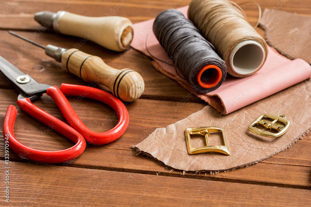 leather craft instruments on wooden background close up