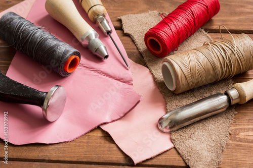 leather craft instruments on wooden background close up