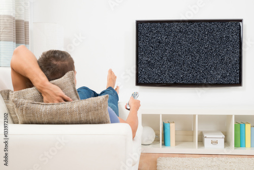 Man With Remote Control Watching Television