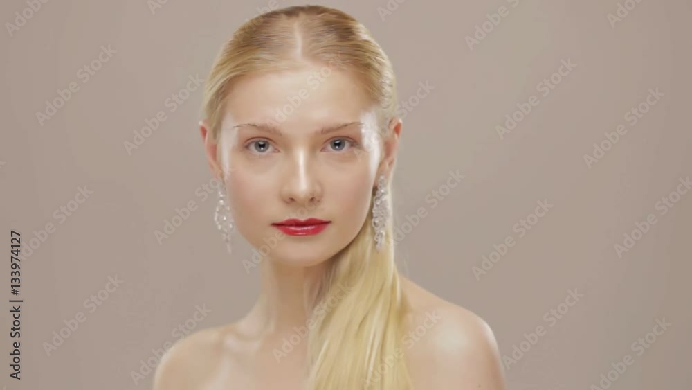 Gorgeous blond girl touching her hair and turn to camera