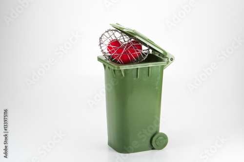 red fabric heart in knitted wire cage on white background