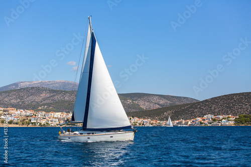 Sailing in the wind through the waves at Aegean Sea in Greece. Luxury yachts.