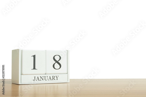 Closeup surface white wooden calendar with black 18 january word on blurred brown wood desk isolated on white background with copy space , selective focus at the calendar