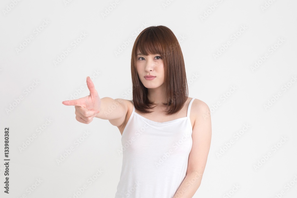 若い女性が指で、ピストルの真似をしています。この画像の背景は白です。 若い女性が指で、ピストルの真似をしています。この画像の背景は白です。