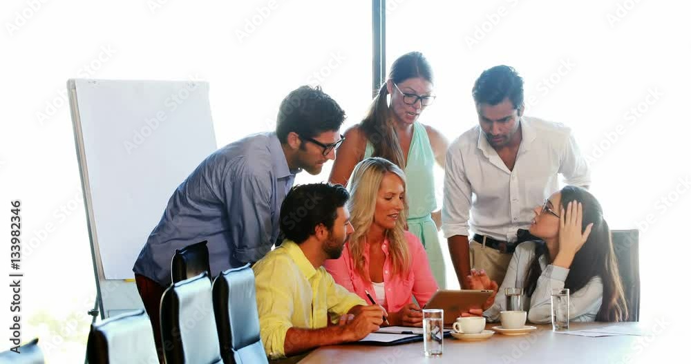 Businesspeople having a discussion while using digital tablet Businesspeople having a discussion while using digital tablet
