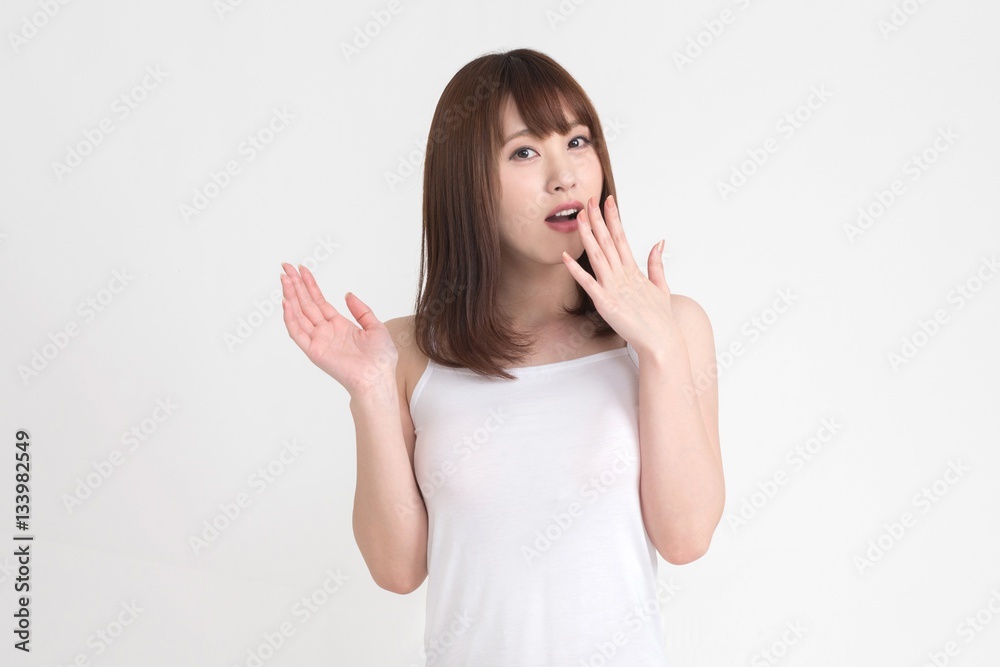 若い女性が驚きやびっくりの表情をしています。画像の背景は白です。 若い女性が驚きやびっくりの表情をしています。画像の背景は白です。