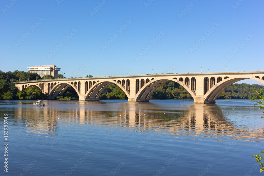 Key Bridge with reflection in Potomac River in Washington DC, USA. Quiet waters of Potomac River in early morning near the scenic bridge.