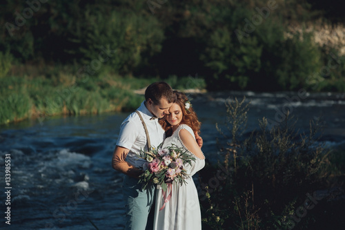 the bride and groom on the background of a mountain stream