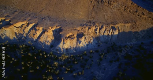 Aerial, Flying Over Palm Oasis Along Mountains At Tissint, Morocco- Graded and stabilized version. Watch also for the native material, straight out of the camera photo