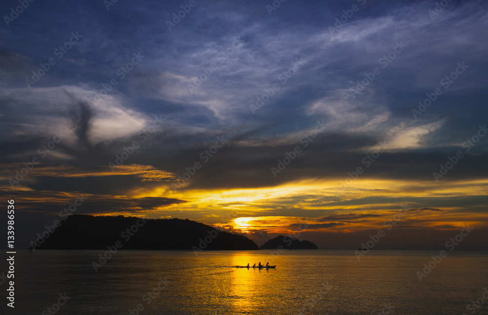 People kayaking in the setting sun of Thailand