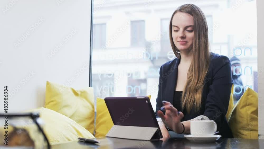 Young Businesswoman Using a Tablet and Smiling Young Businesswoman Using a Tablet and Smiling