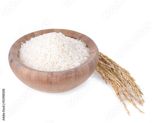 white rice on the wooden plate and rice plant , uncooked raw