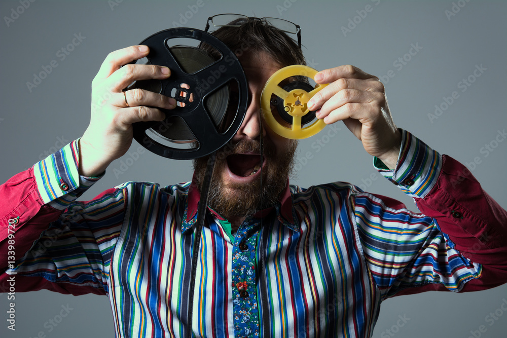 Obraz premium Bearded man with two 16mm film reel