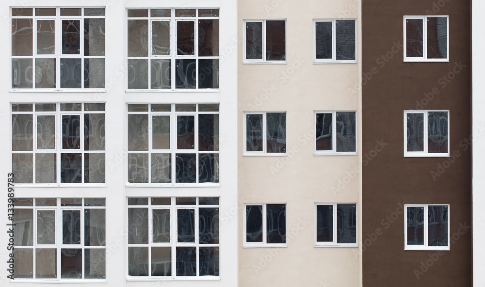 Wall of a residential block of flats with balconies windows