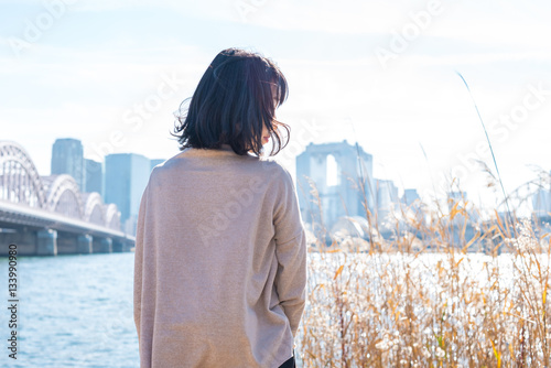 河原で都市を眺める女性 photo