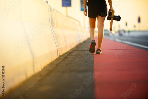 woman walk on bike paths with camera in evening