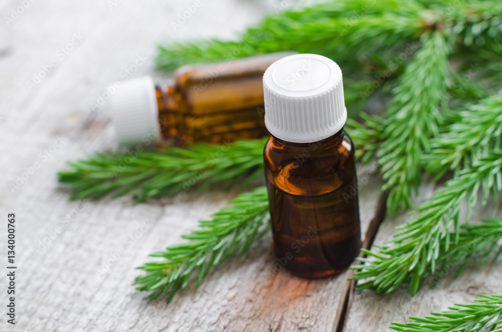 Two bottles of essential oil and fir branches. Aromatherapy and spa products