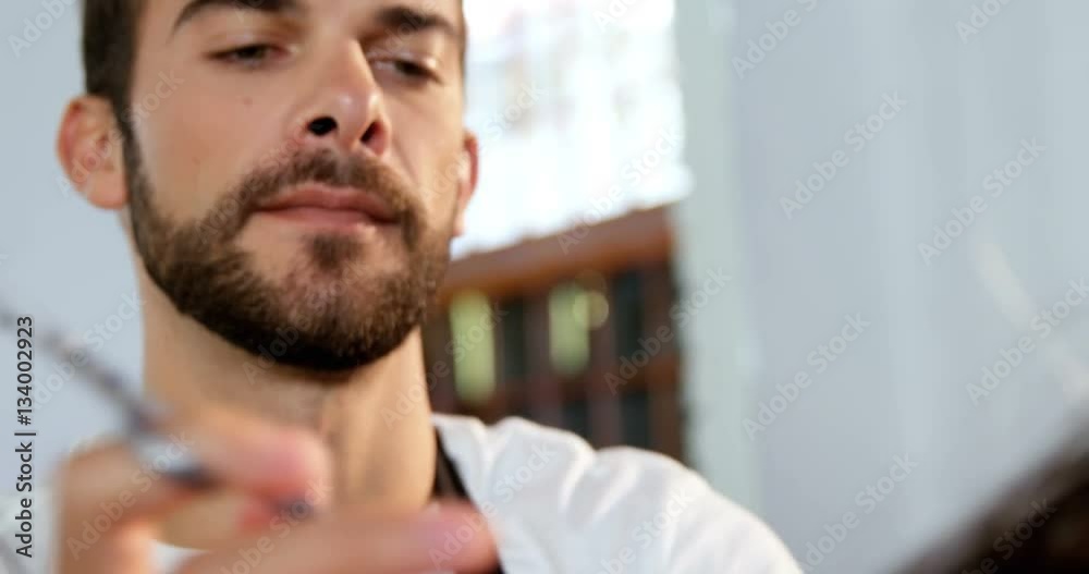 Male hairdresser cutting a womans hair with scissor