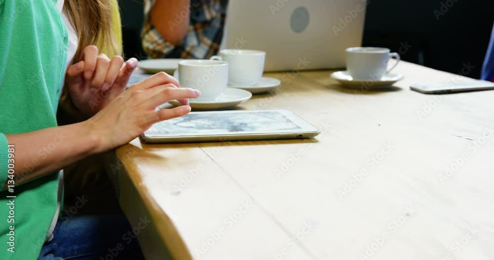 Woman using digital tablet while having coffee Woman using digital tablet while having coffee