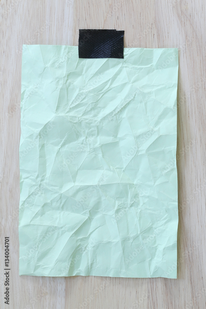 Obraz premium Green notepad paper wrinkled of empty and copy space on wooden b