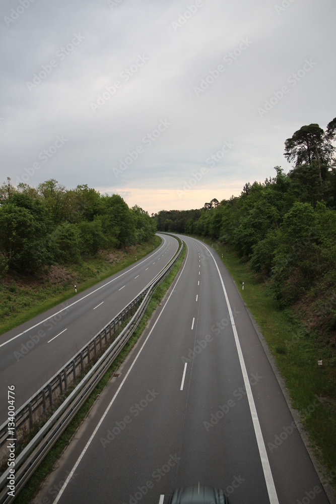 Fototapeta premium Autobahn Straße road empty Germany sky nature trees forest cars drive clouds
