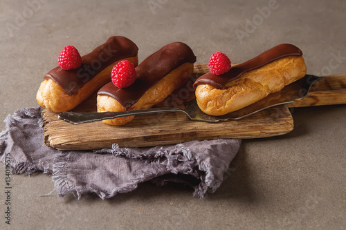 Traditional French dessert. Eclair with chocolate icing and rasp